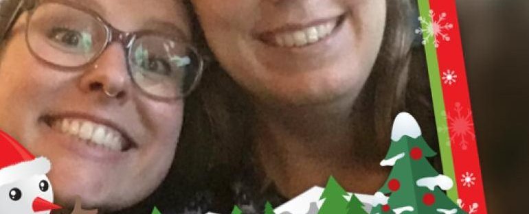 Grappige selfie van Eline en Tamar in een kitcherig kerstframe met een sneeuwpop en kerstbomen