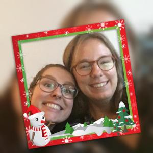 Grappige selfie van Eline en Tamar in een kitsch kerstframe met een sneeuwpop en kerstbomen